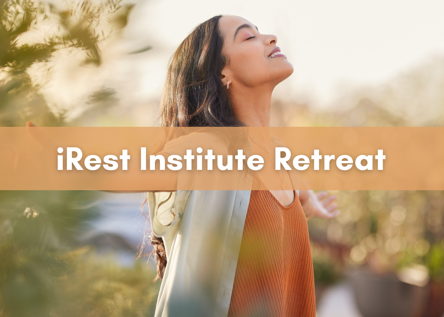 Person standing outdoors with eyes closed and arms open in a gesture of ease, with a tan banner reading ‘iRest Institute Retreat.’